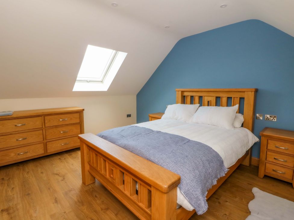 A bedroom with a bed and nightstands at Y Stabal near Llanilar