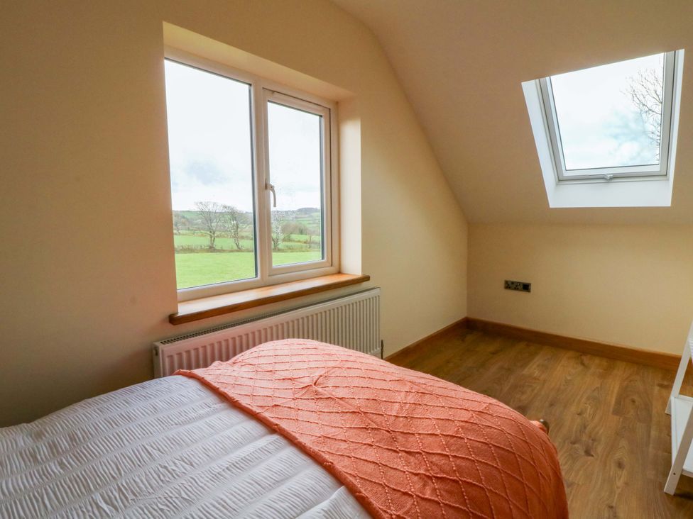 A bedroom with a bed and a window at Y Stabal near Llanilar