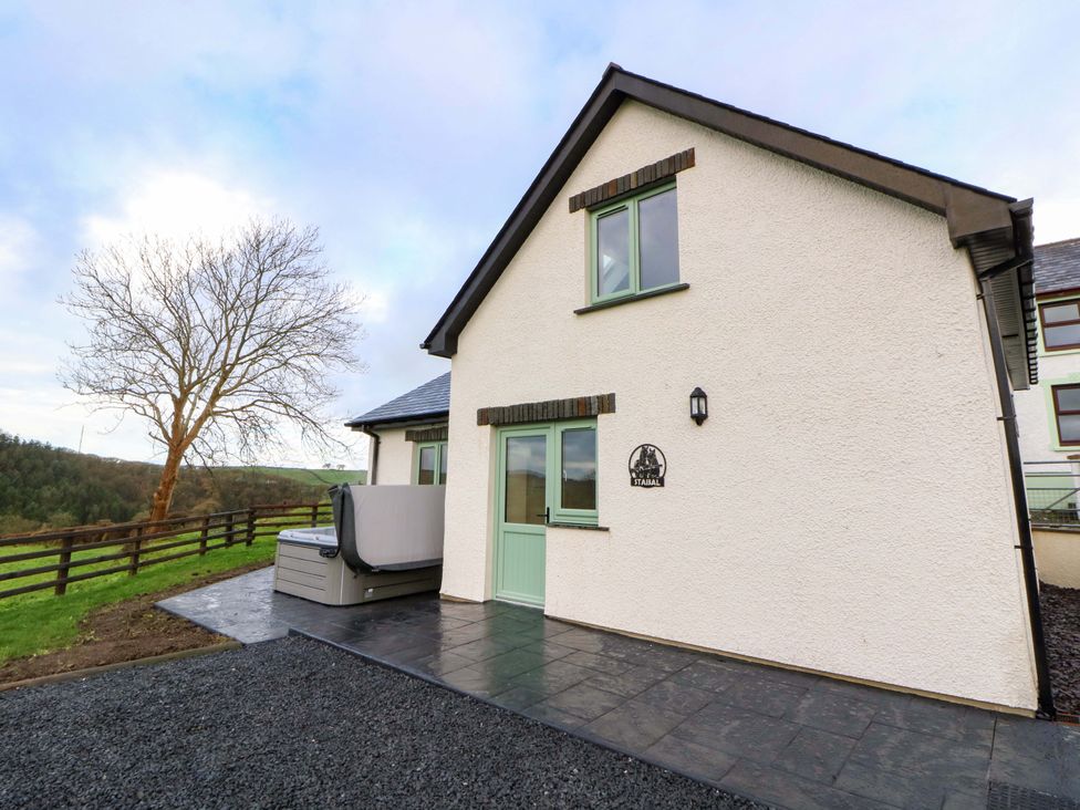 An outdoor view of a house with a patio and hot tub at Y Stabal near Llanilar