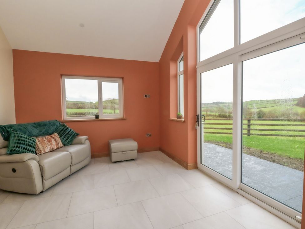 A snug with a sofa and footrest at Y Stabal near Llanilar