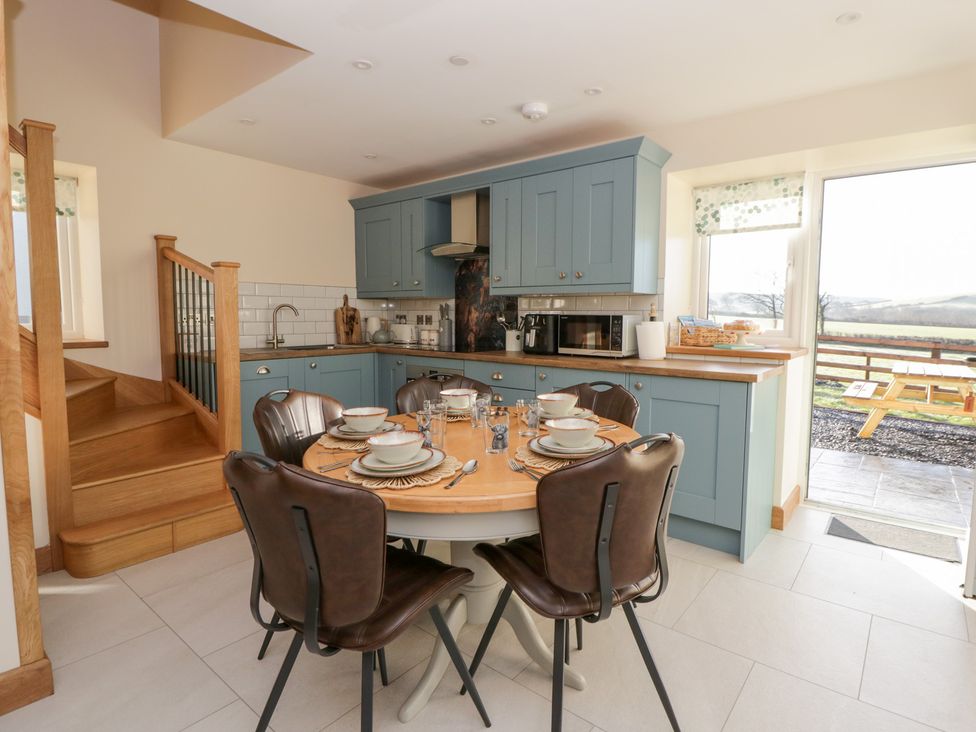 A kitchen with a table set for meals at Y Stabal near Llanilar