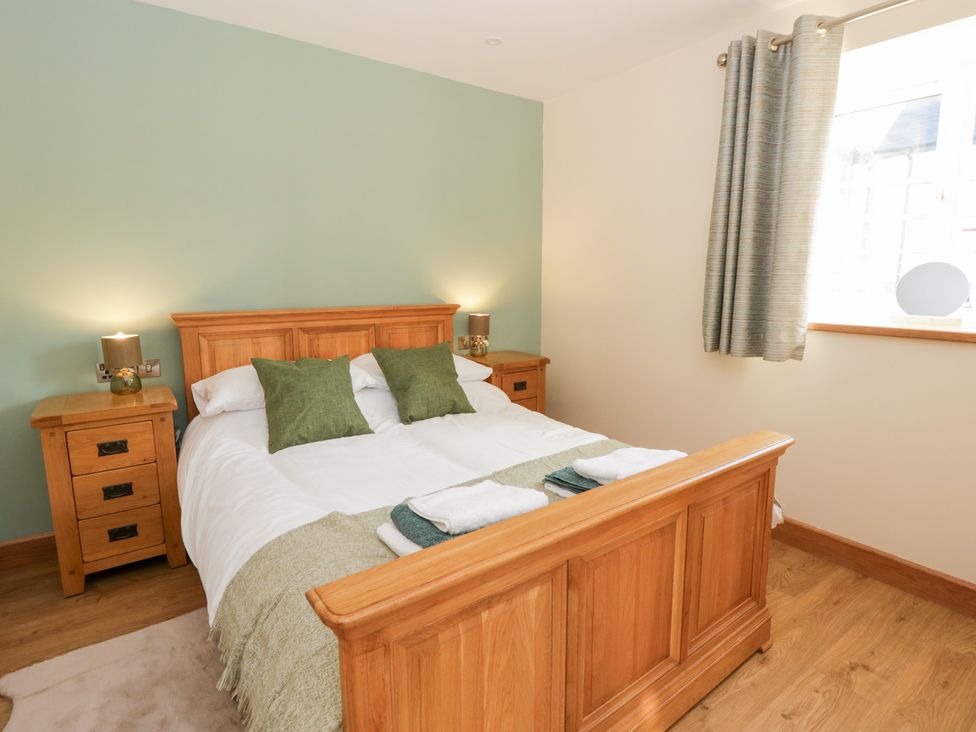 A bedroom with a bed and bedside tables at Y Stabal near Llanilar