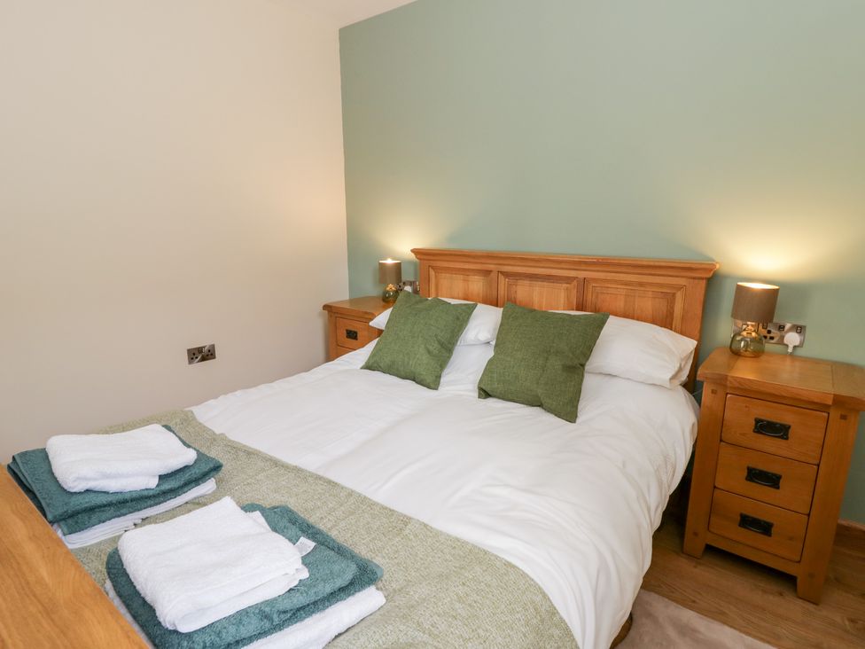 A bedroom with a bed and nightstands at Y Stabal near Llanilar