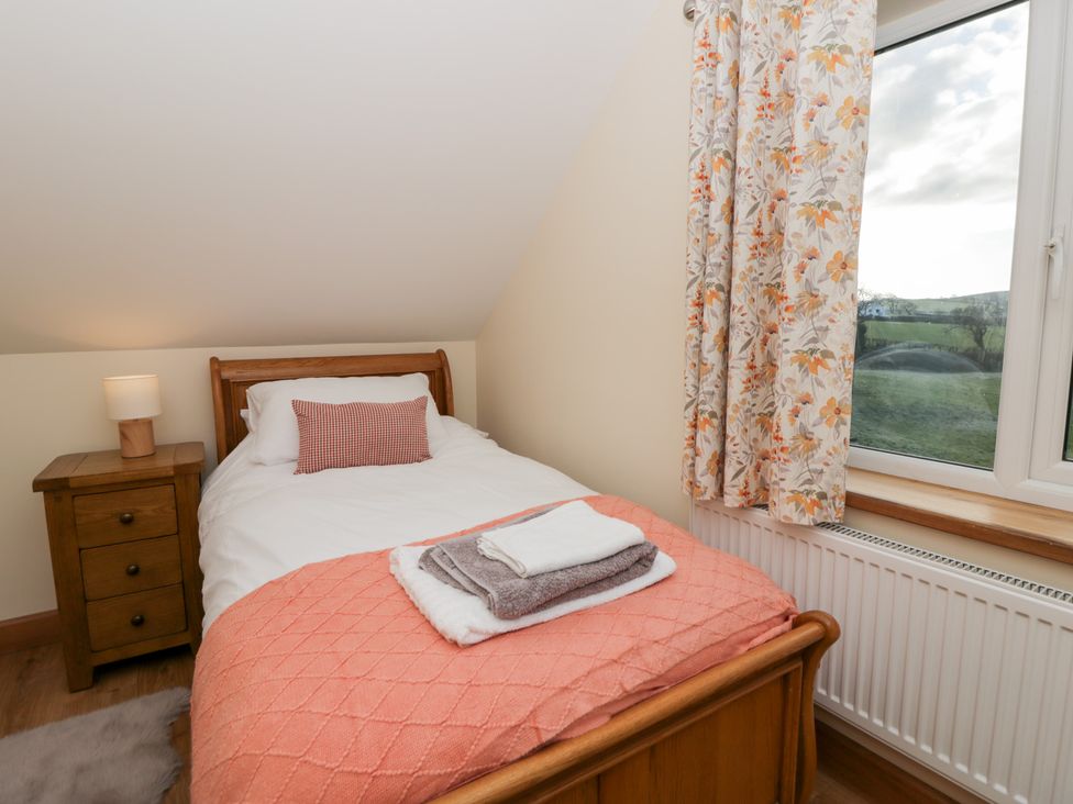 A bedroom with a bed and nightstand at Y Stabal near Llanilar