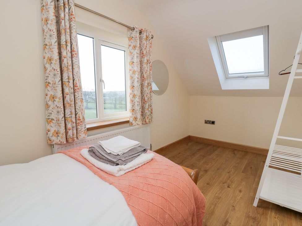 A bedroom with a bed and towels in Y Stabal near Llanilar