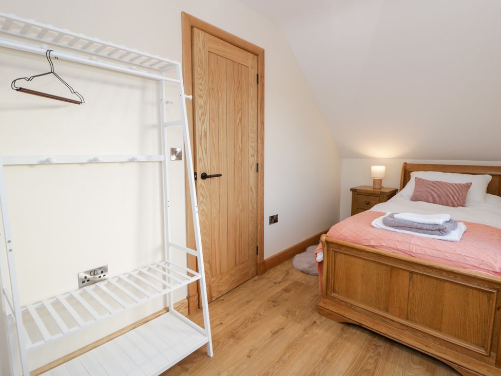 A bedroom with a bed and bedside table at Y Stabal near Llanilar