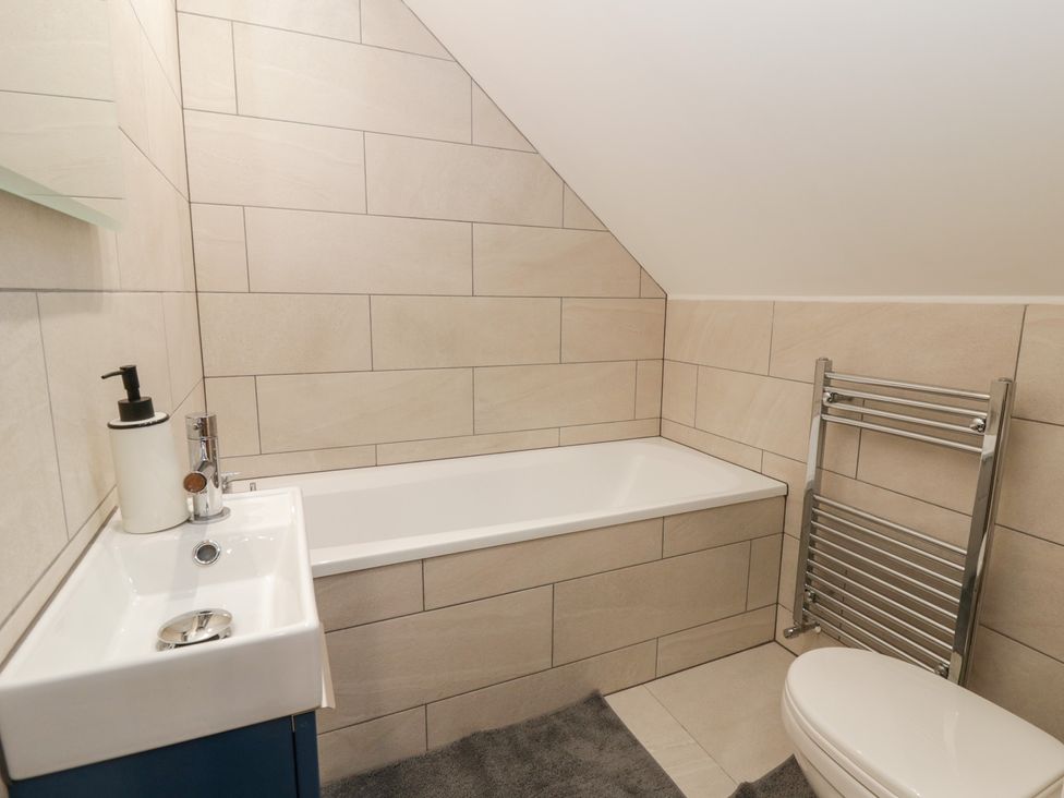 A bathroom with a bath tub, sink, and toilet at Y Stabal near Llanilar