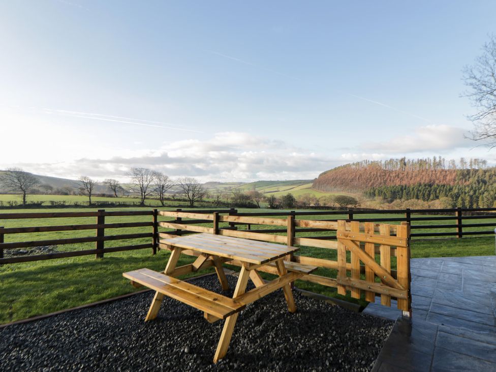 A picnic table and fence with a grassy area at Y Stabal near Llanilar