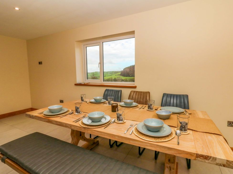 A dining room with a table set for meals at Y Beudy near Llanilar
