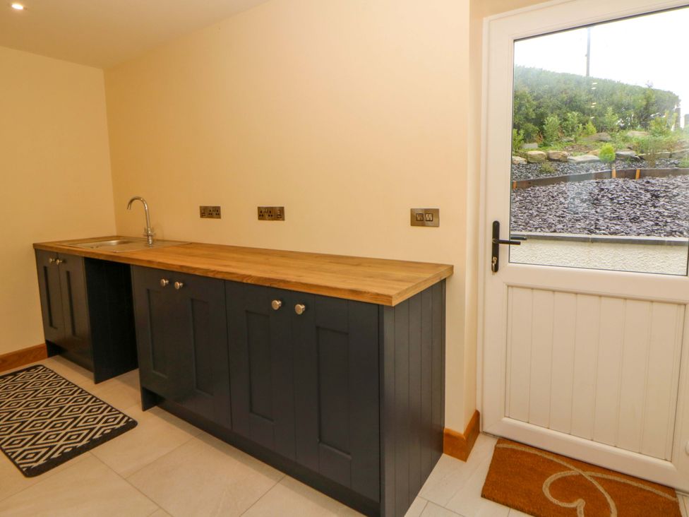 A kitchen with cabinets and a sink at Y Beudy near Llanilar