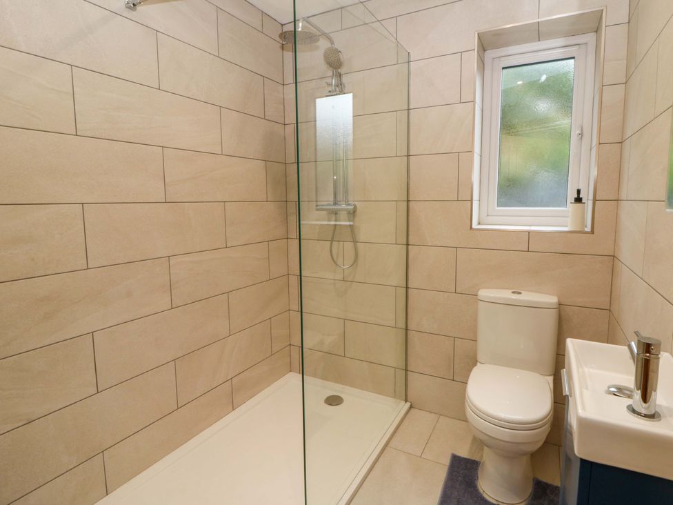 A bathroom with shower, toilet, and sink at Y Beudy near Llanilar