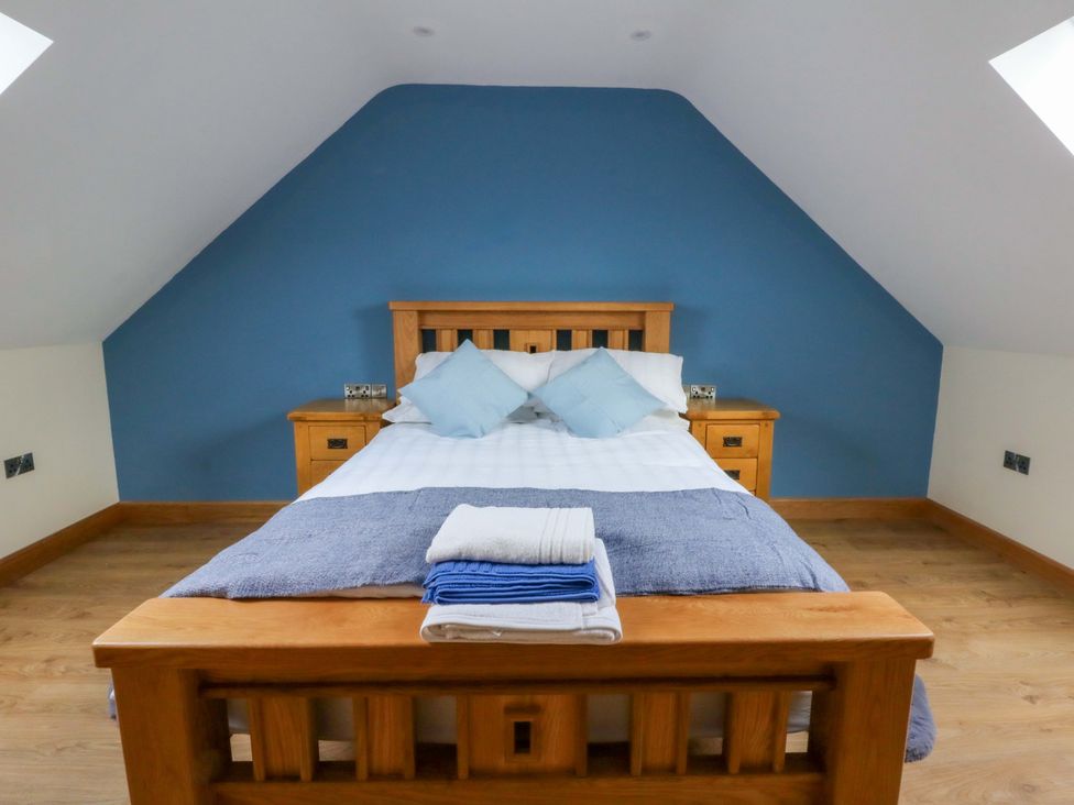 A bedroom with a bed and nightstands at Y Beudy near Llanilar