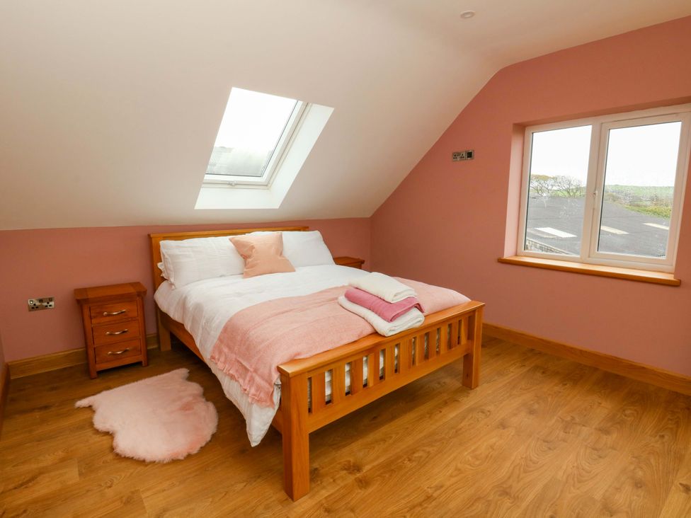 A bedroom with a bed and nightstand at Y Beudy near Llanilar