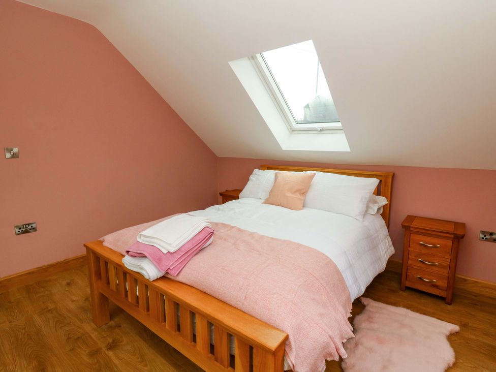 A bedroom with a bed and nightstand at Y Beudy near Llanilar
