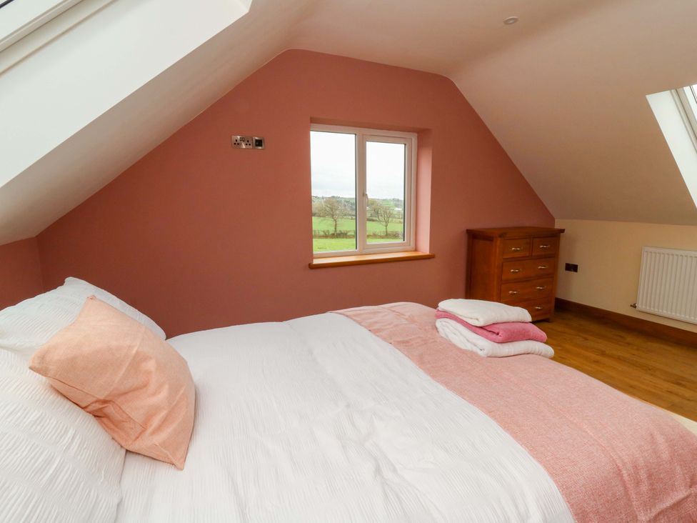 A bedroom with a bed and window at Y Beudy near Llanilar