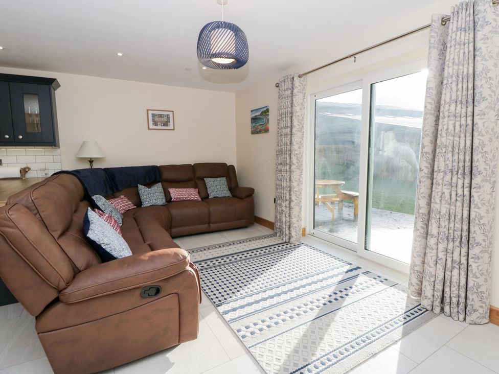 A living room with a sofa and sliding door at Beudy near Llanilar