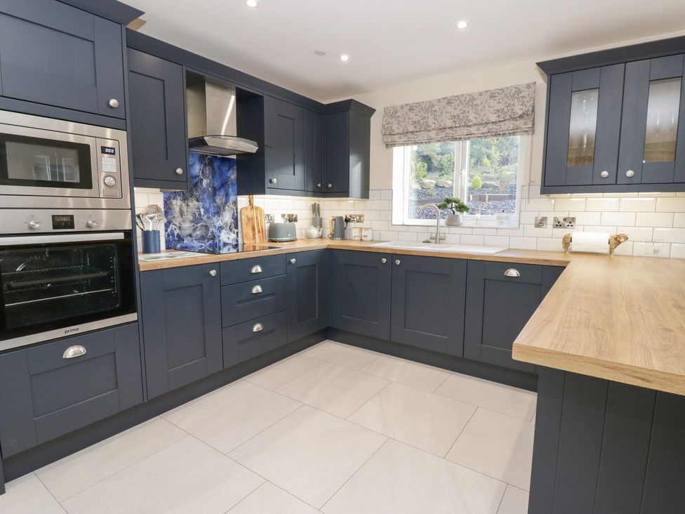A kitchen with cabinets and appliances at Beudy near Llanilar