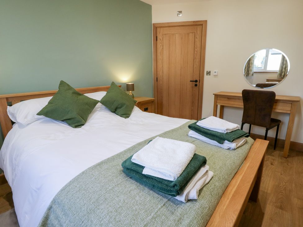 A bedroom with a bed and a mirror at Beudy near Llanilar