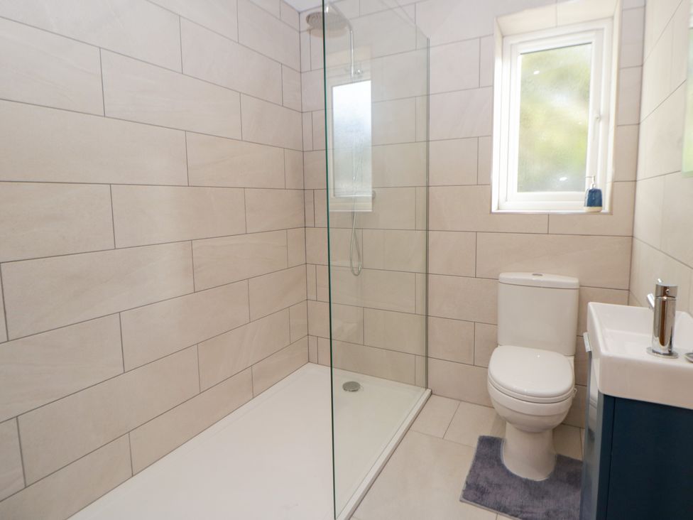 A bathroom with a shower, toilet, and sink at Beudy near Llanilar