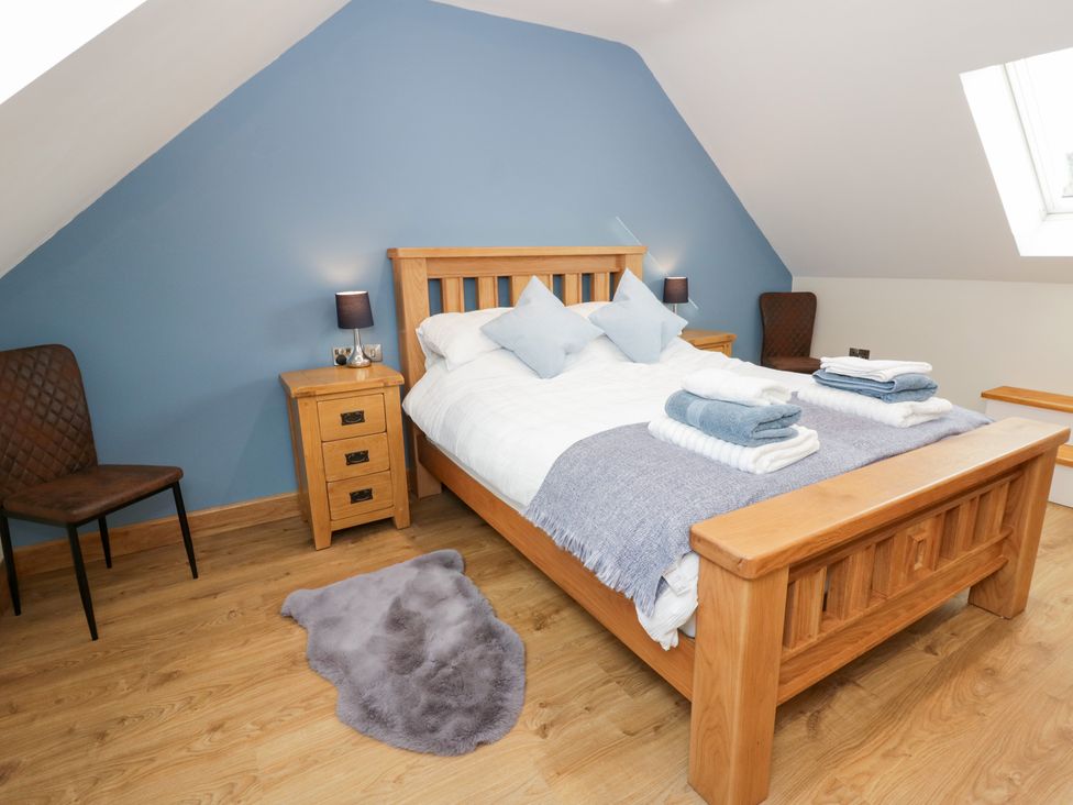 A bedroom with a bed and bedside table at Beudy near Llanilar