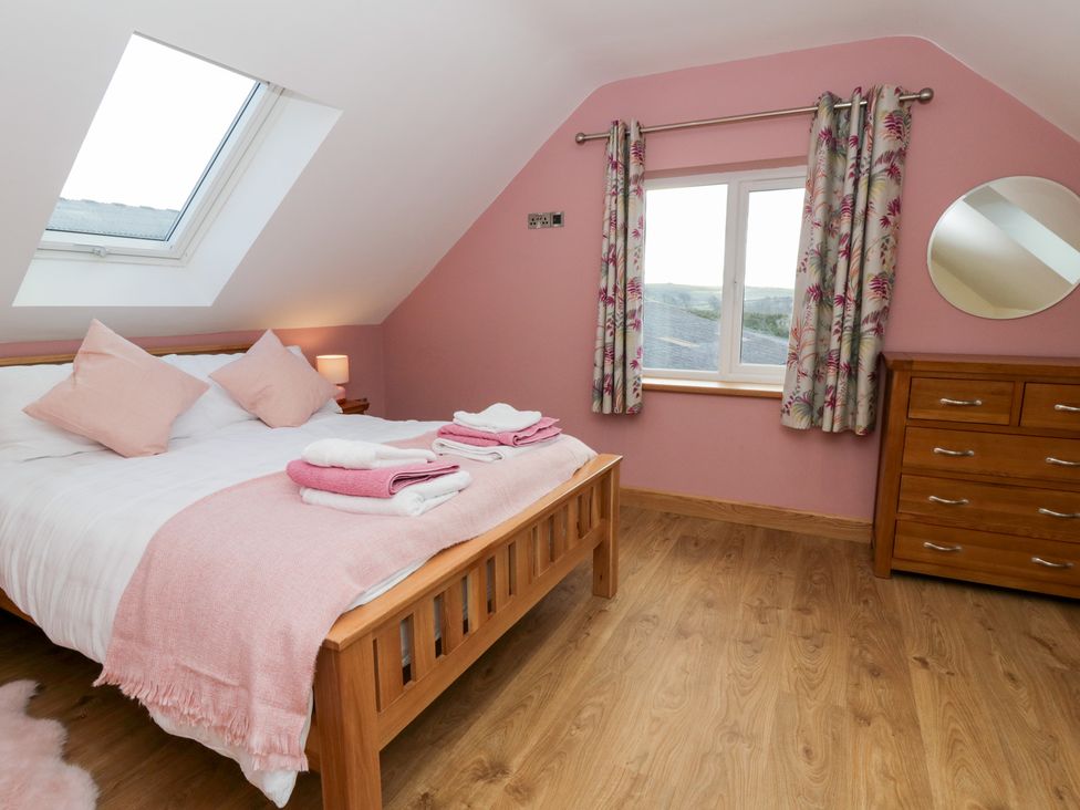 A bedroom with a bed and dresser at Beudy near Llanilar