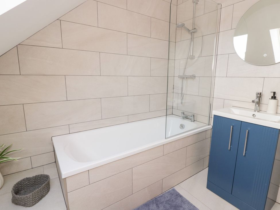 A bathroom with a bathtub and vanity at Beudy near Llanilar