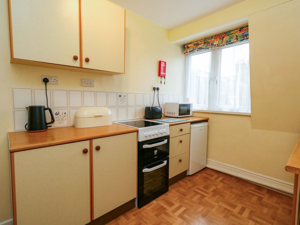 A kitchen with cabinets and appliances at Bay View in Swanage