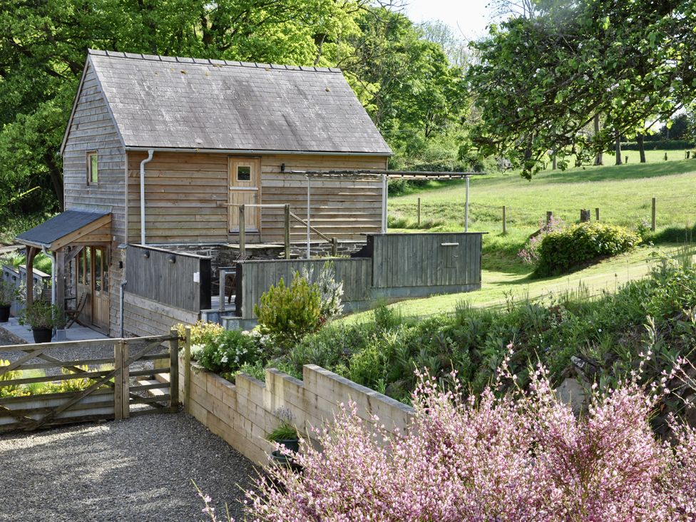 A wooden cabin with steps and garden area at Rockhill Farm Hay Barn in Clun