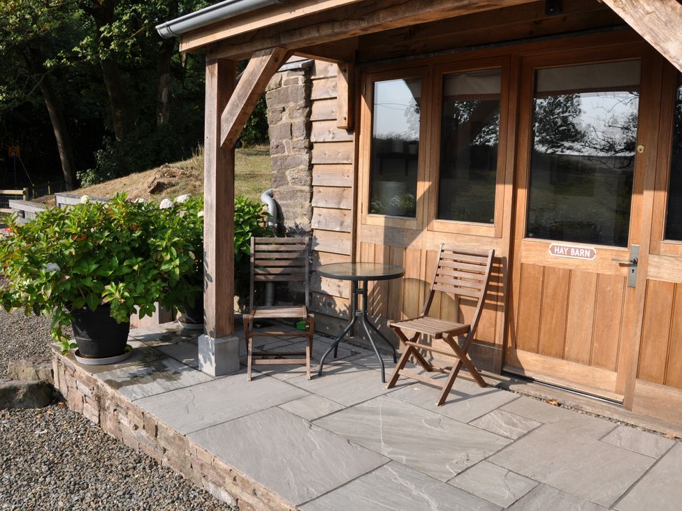 An outdoor area with a table and chairs at Rockhill Farm Hay Barn in Clun