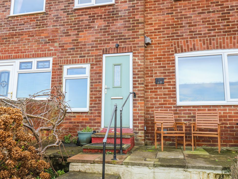 A doorway with steps and chairs outside at Whitby View in Whitby