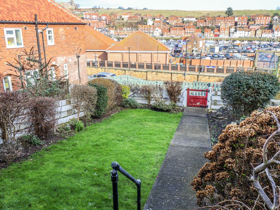 A garden with grass, pathway, and bushes at Whitby View in Whitby