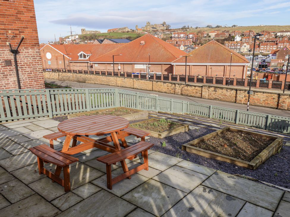 A garden with a table and benches at Whitby View in Whitby