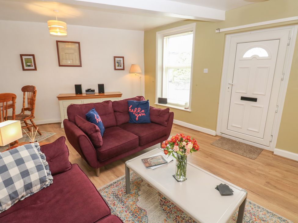 A living room with a sofa and a table at 1 Eden Cottages in Corby Hill