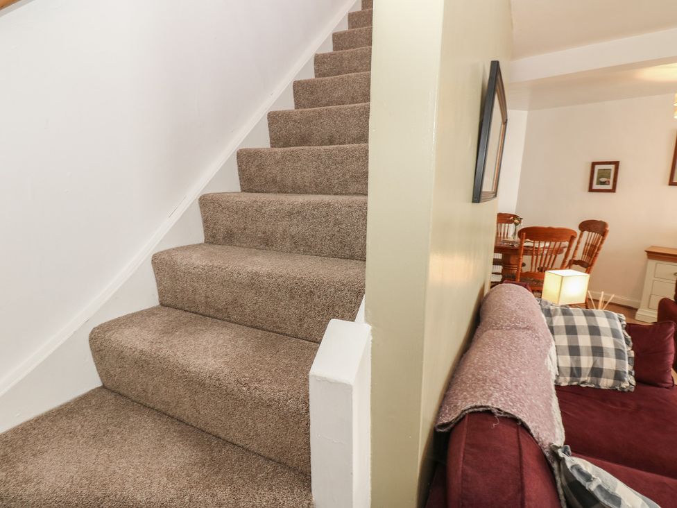 Stairs leading to upper areas with a view of the living room at 1 Eden Cottages Corby Hill