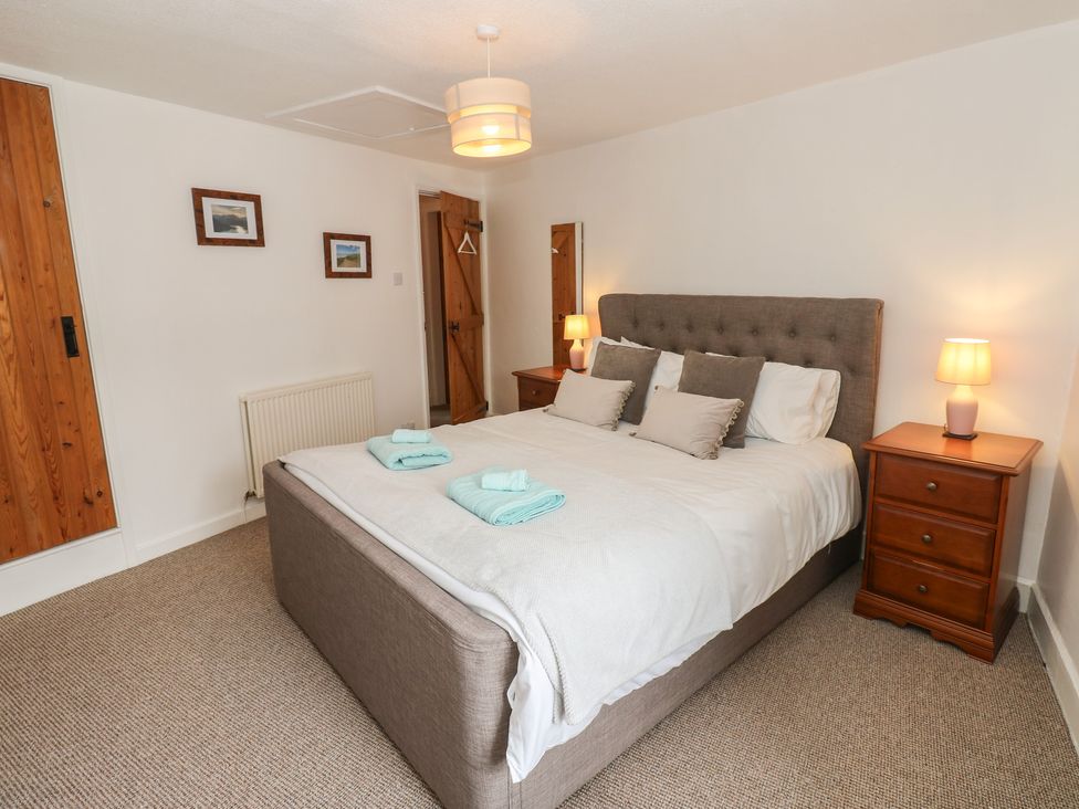 A bedroom with a bed and bedside tables at 1 Eden Cottages in Corby Hill