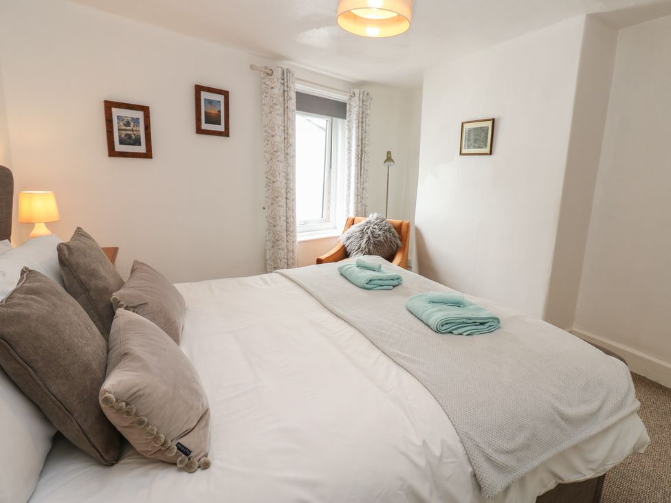 A bedroom with a bed and decorative pictures at 1 Eden Cottages Corby Hill