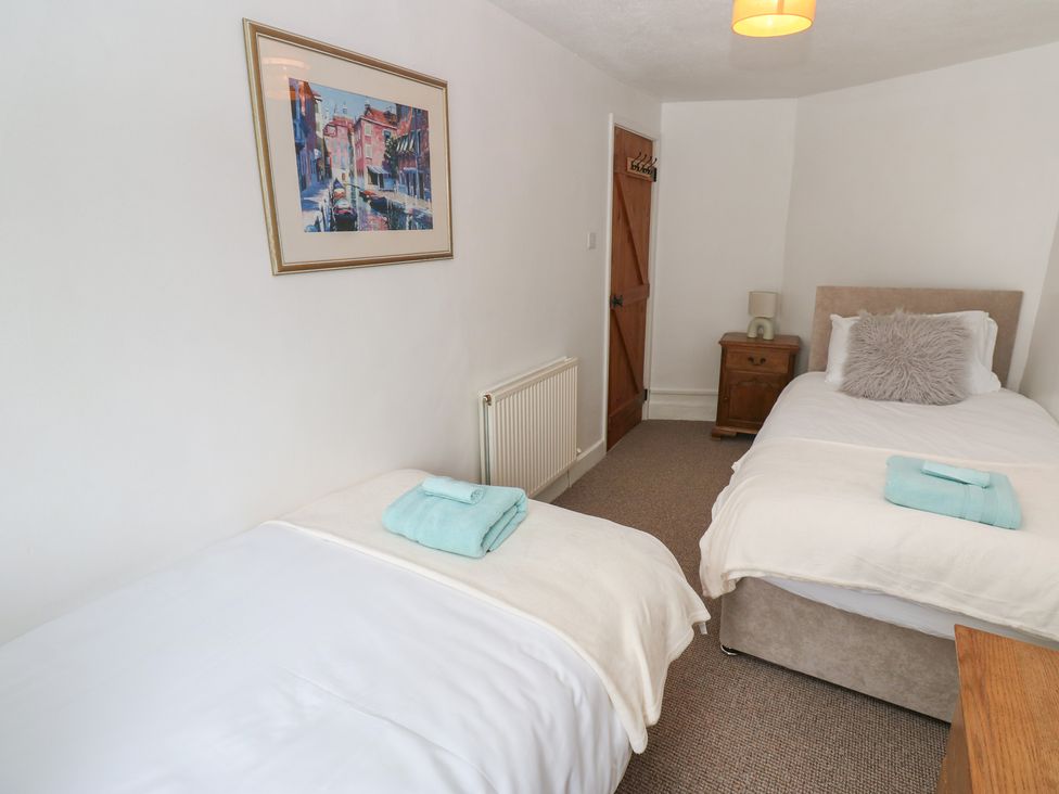 A bedroom with two single beds and a nightstand at 1 Eden Cottages Corby Hill