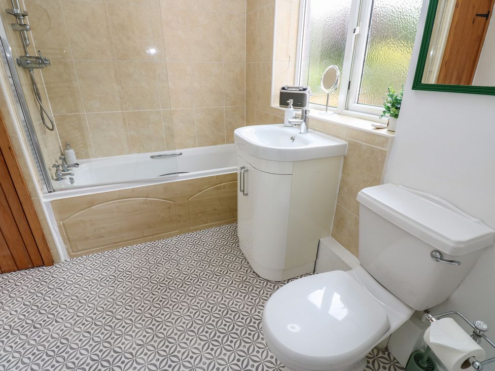 A bathroom with a bathtub, sink, and toilet at 1 Eden Cottages in Corby Hill