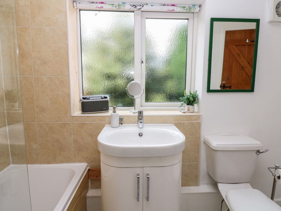 A bathroom with a sink, toilet, and bathtub at 1 Eden Cottages Corby Hill