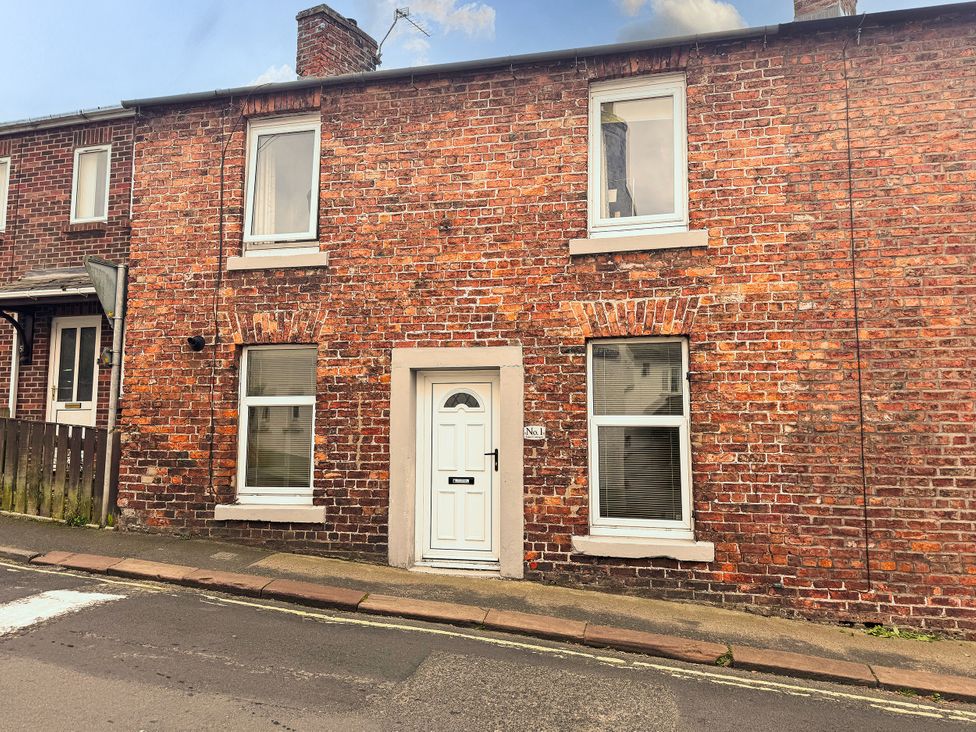 A house facade with brick wall and front door at 1 Eden Cottages Corby Hill