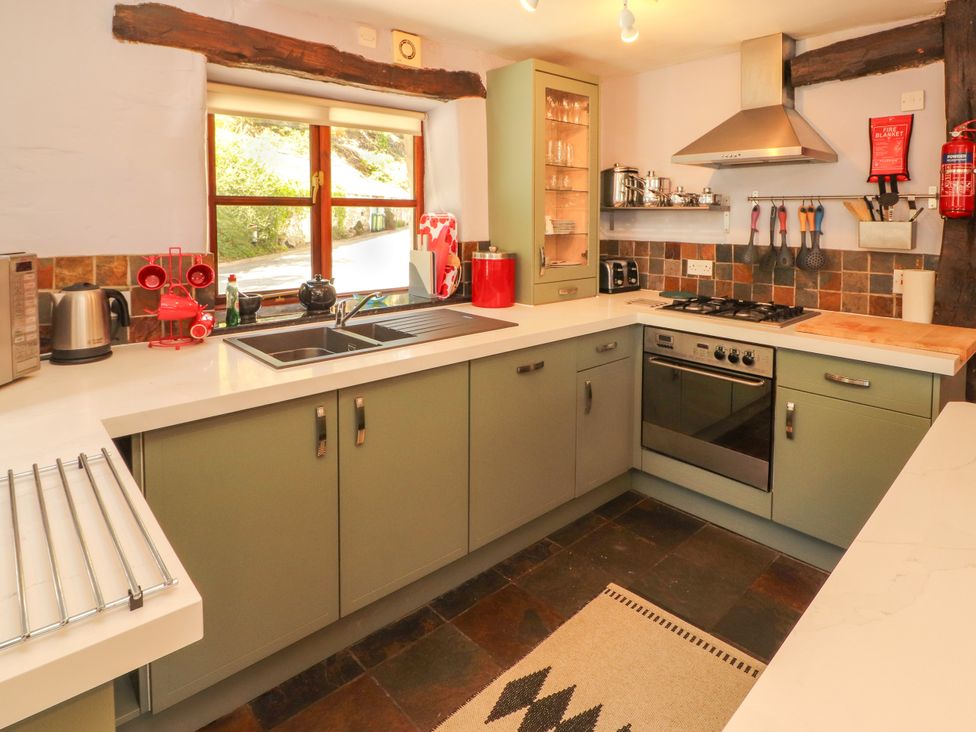 A kitchen with a sink, oven, stove, and countertop at Beck Edge in Braithwaite