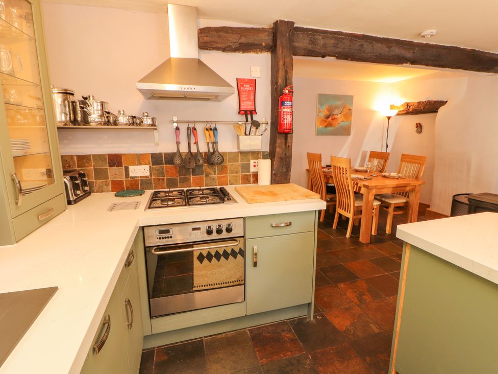 A kitchen with stove and dining table at Beck Edge in Braithwaite