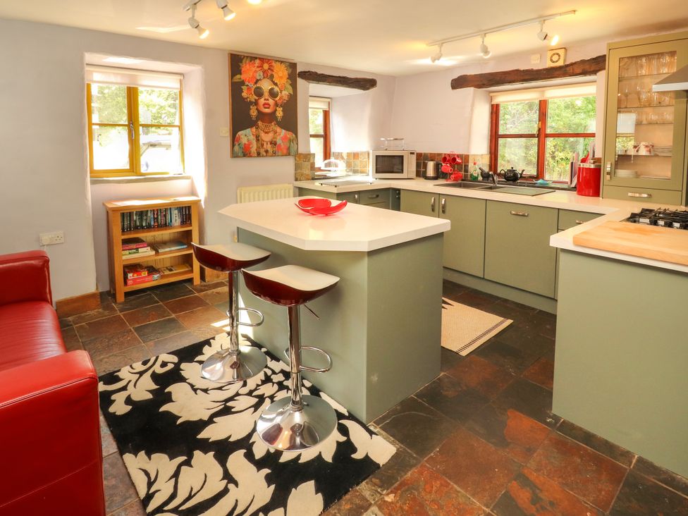 A kitchen with bar stools and a microwave at Beck Edge in Braithwaite