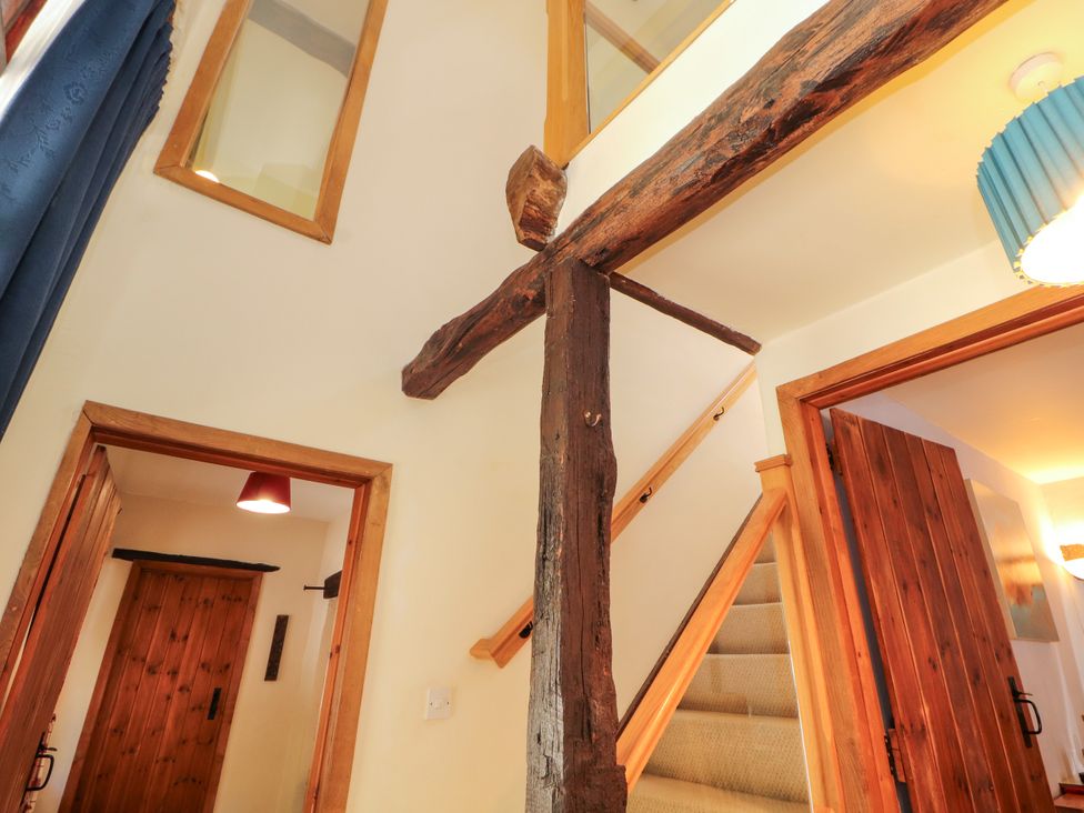 A hallway with stairs and wooden beams at Beck Edge in Braithwaite