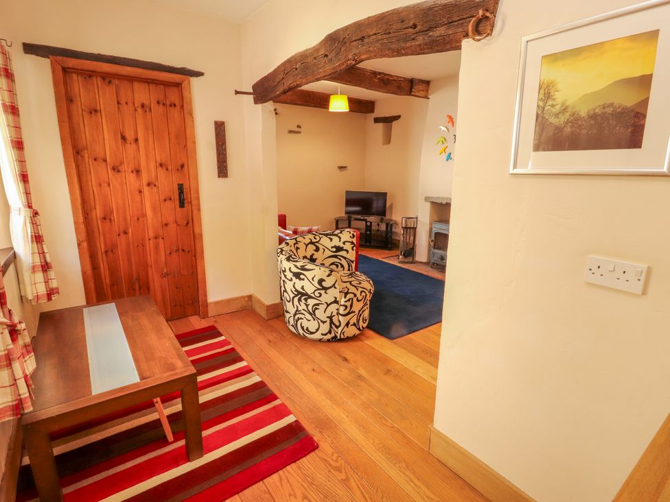A living room with a table and chair at Beck Edge in Braithwaite