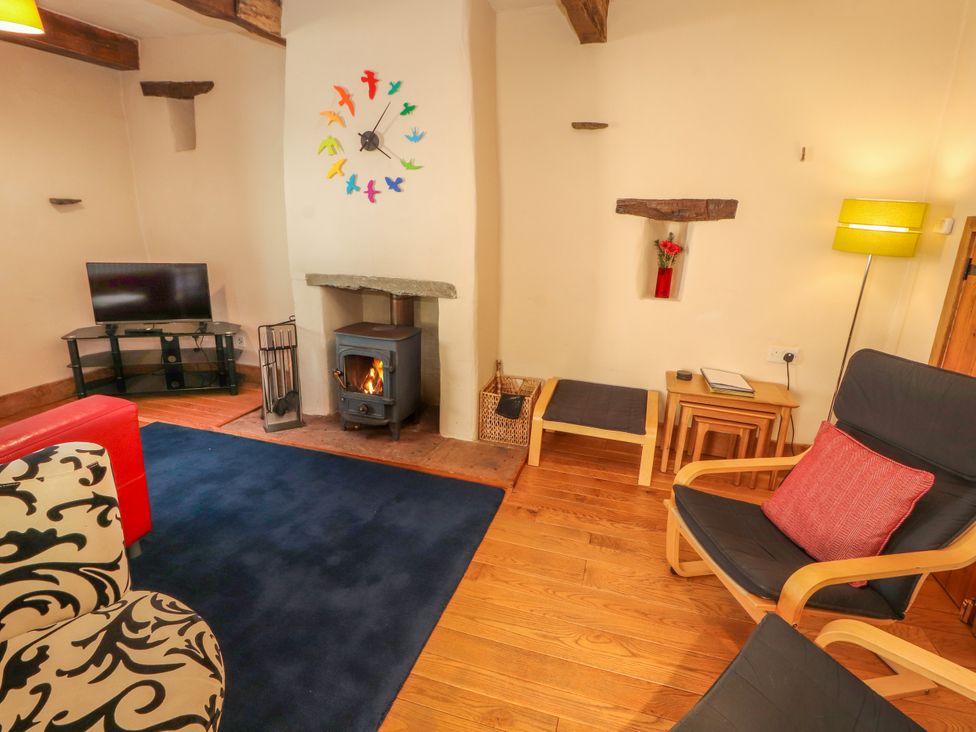 A living room with a fireplace and a television at Beck Edge in Braithwaite