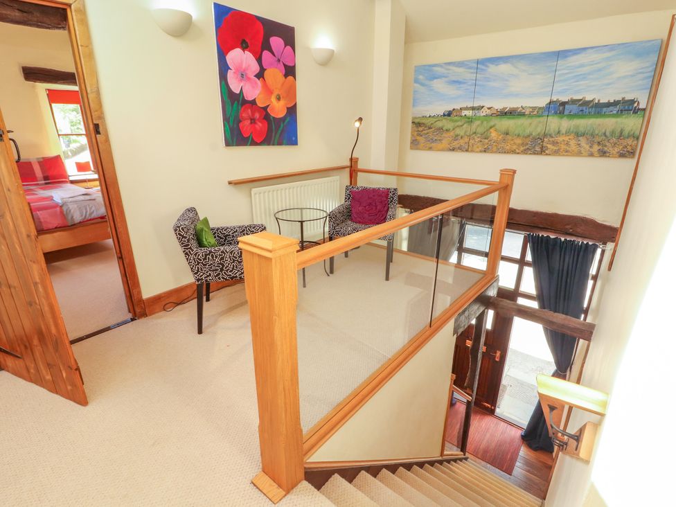 A landing with a staircase and wall art at Beck Edge in Braithwaite