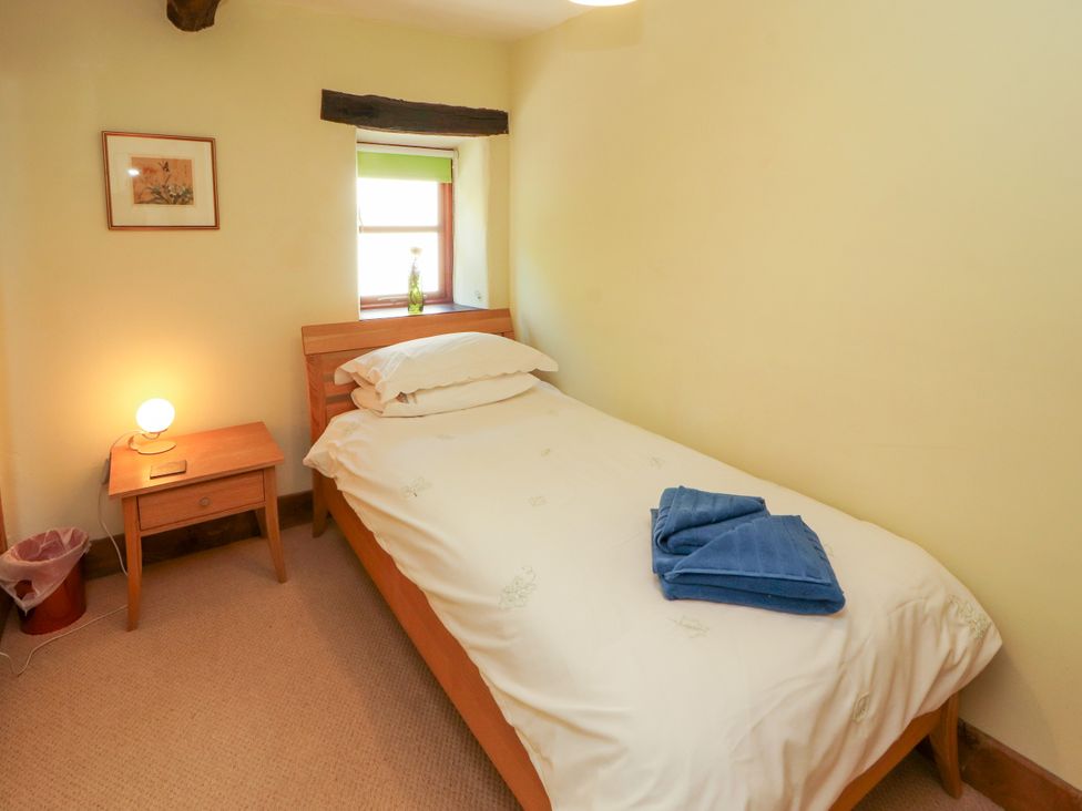 A bedroom with a bed and lamp at Beck Edge in Braithwaite