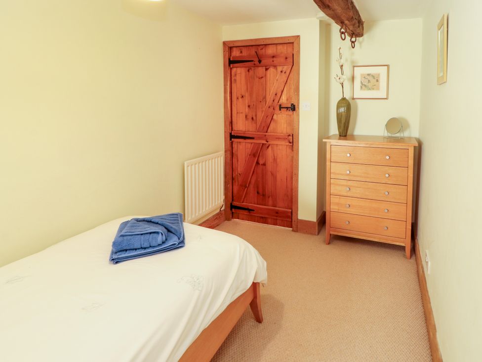 A bedroom with a bed and dresser at Beck Edge in Braithwaite