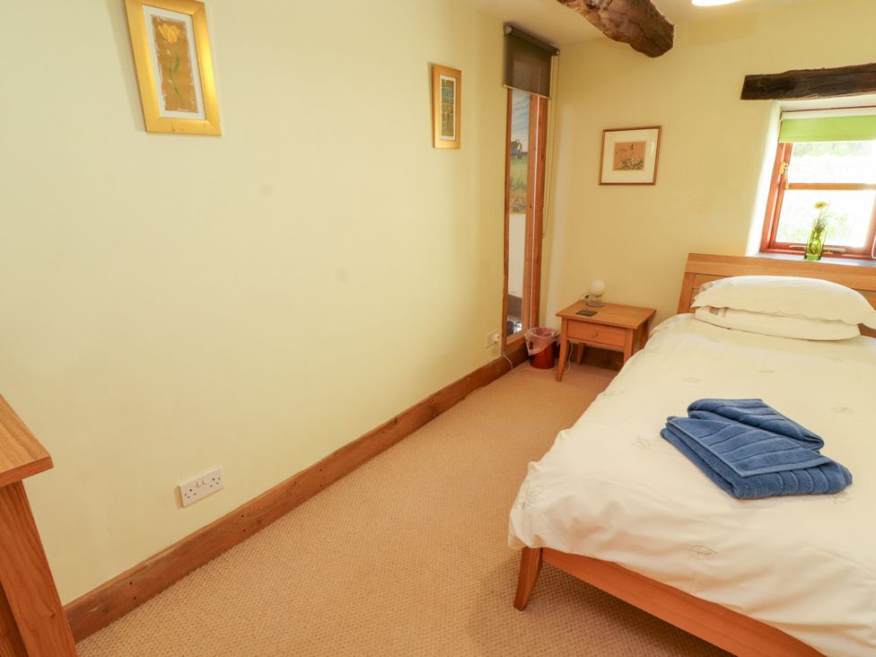 A bedroom with a bed and side table at Beck Edge in Braithwaite